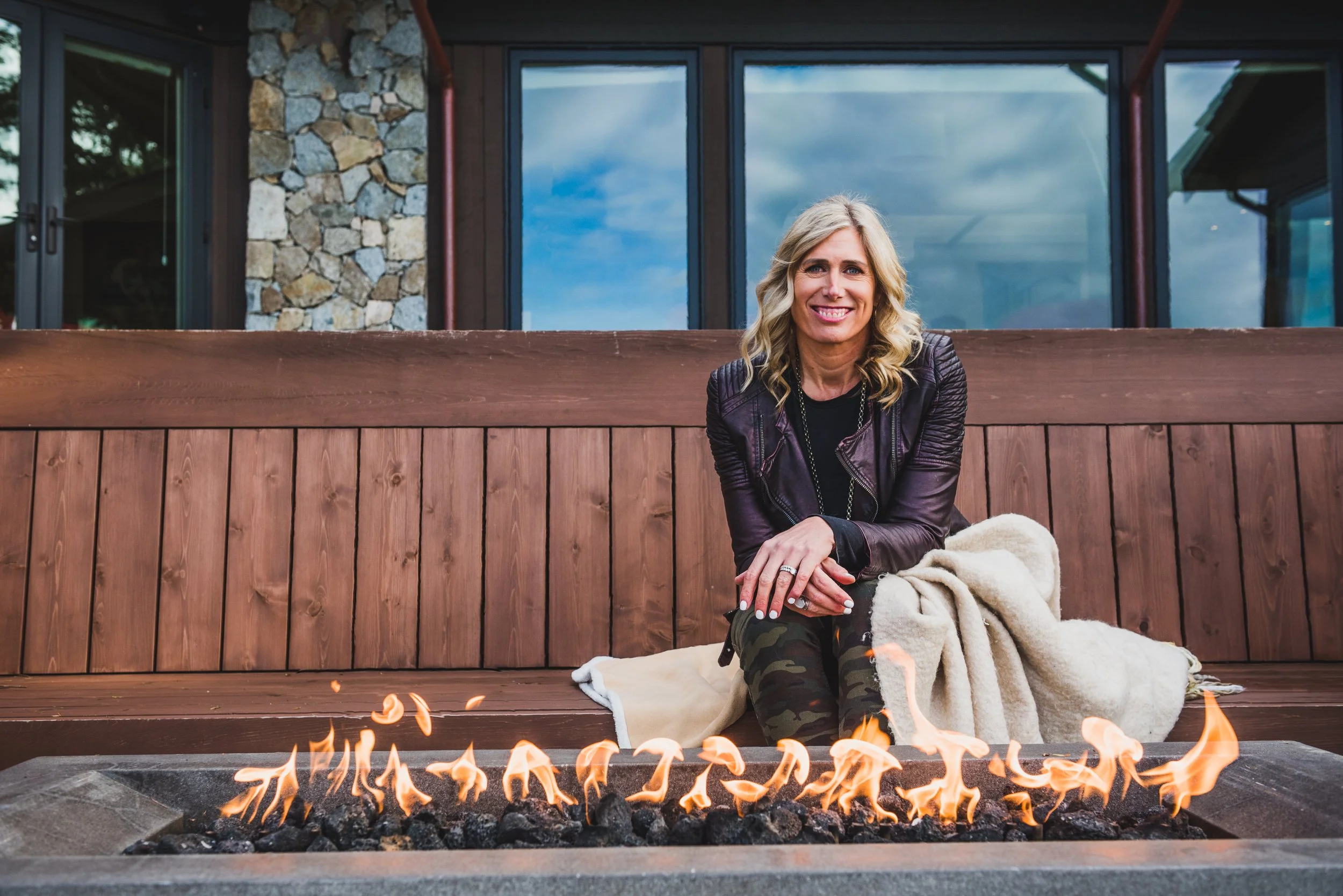 Silken Laumann sitting by an outdoor fire